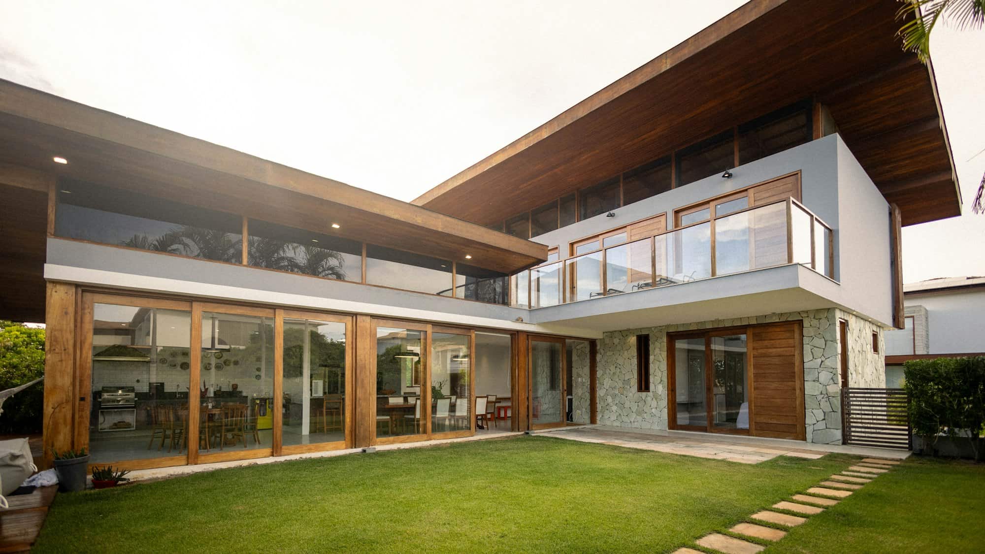 Façade d’une maison contemporaine aux grandes baies vitrées, ouverte sur son jardin