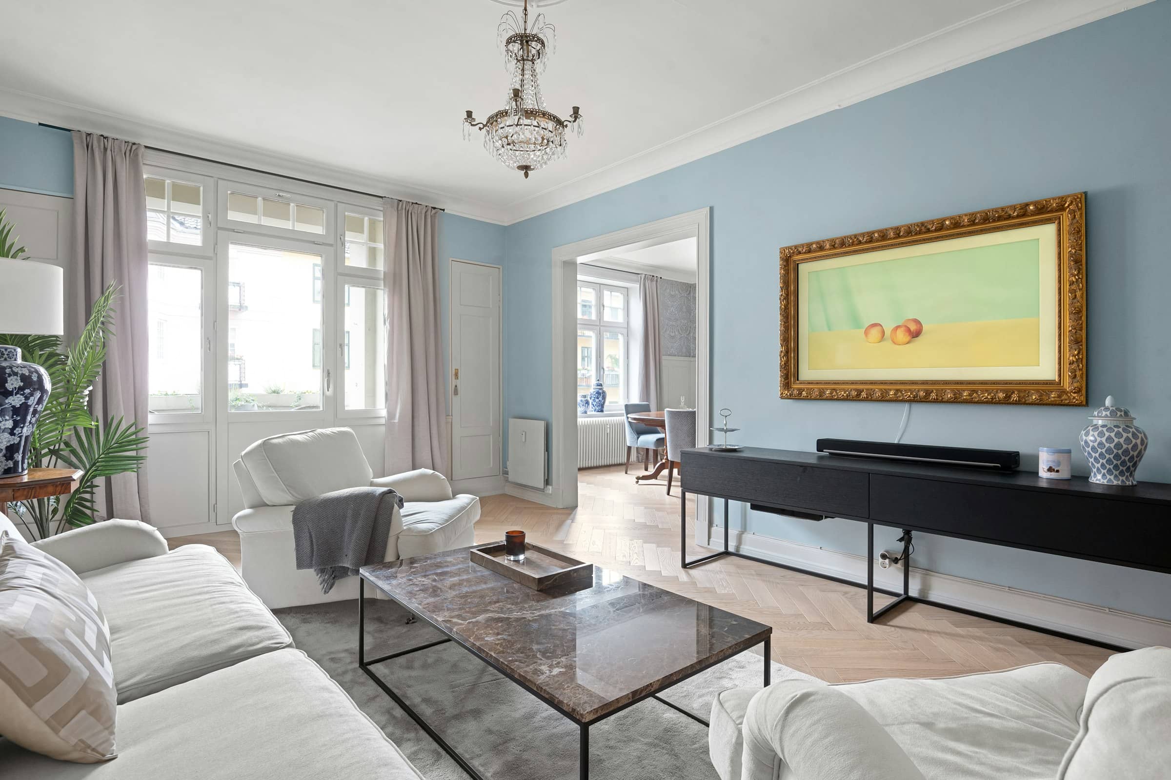 Salon lumineux aux moulures claires, meublé avec sobriété