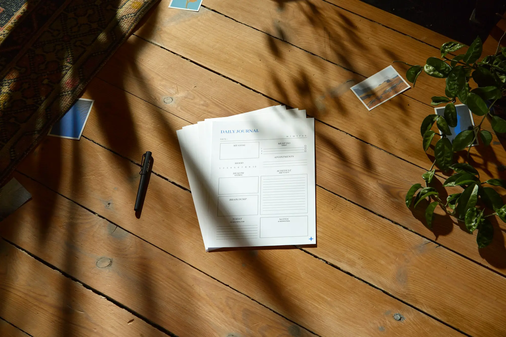 Table en bois clair, documents et stylo posés dans la lumière du jour